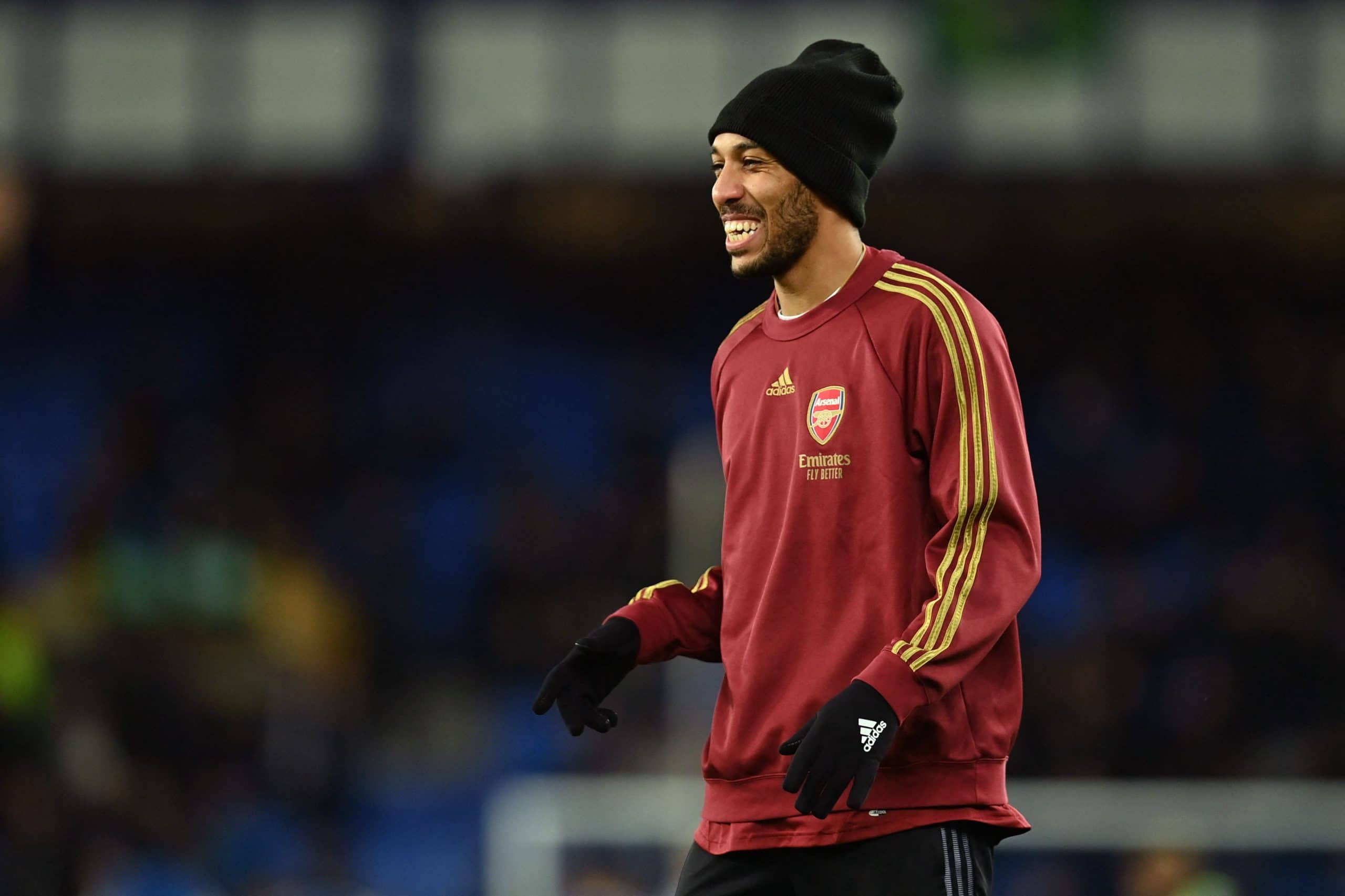 Arsenal's Gabonese striker Pierre-Emerick Aubameyang smiles during warm up for the English Premier League football match between Everton and Arsenal at Goodison Park in Liverpool, north west England on December 6, 2021. - RESTRICTED TO EDITORIAL USE. No use with unauthorized audio, video, data, fixture lists, club/league logos or 'live' services. Online in-match use limited to 120 images. An additional 40 images may be used in extra time. No video emulation. Social media in-match use limited to 120 images. An additional 40 images may be used in extra time. No use in betting publications, games or single club/league/player publications. (Photo by Paul ELLIS / AFP) / RESTRICTED TO EDITORIAL USE. No use with unauthorized audio, video, data, fixture lists, club/league logos or 'live' services. Online in-match use limited to 120 images. An additional 40 images may be used in extra time. No video emulation. Social media in-match use limited to 120 images. An additional 40 images may be used in extra time. No use in betting publications, games or single club/league/player publications. / RESTRICTED TO EDITORIAL USE. No use with unauthorized audio, video, data, fixture lists, club/league logos or 'live' services. Online in-match use limited to 120 images. An additional 40 images may be used in extra time. No video emulation. Social media in-match use limited to 120 images. An additional 40 images may be used in extra time. No use in betting publications, games or single club/league/player publications. (Photo by PAUL ELLIS/AFP via Getty Images)