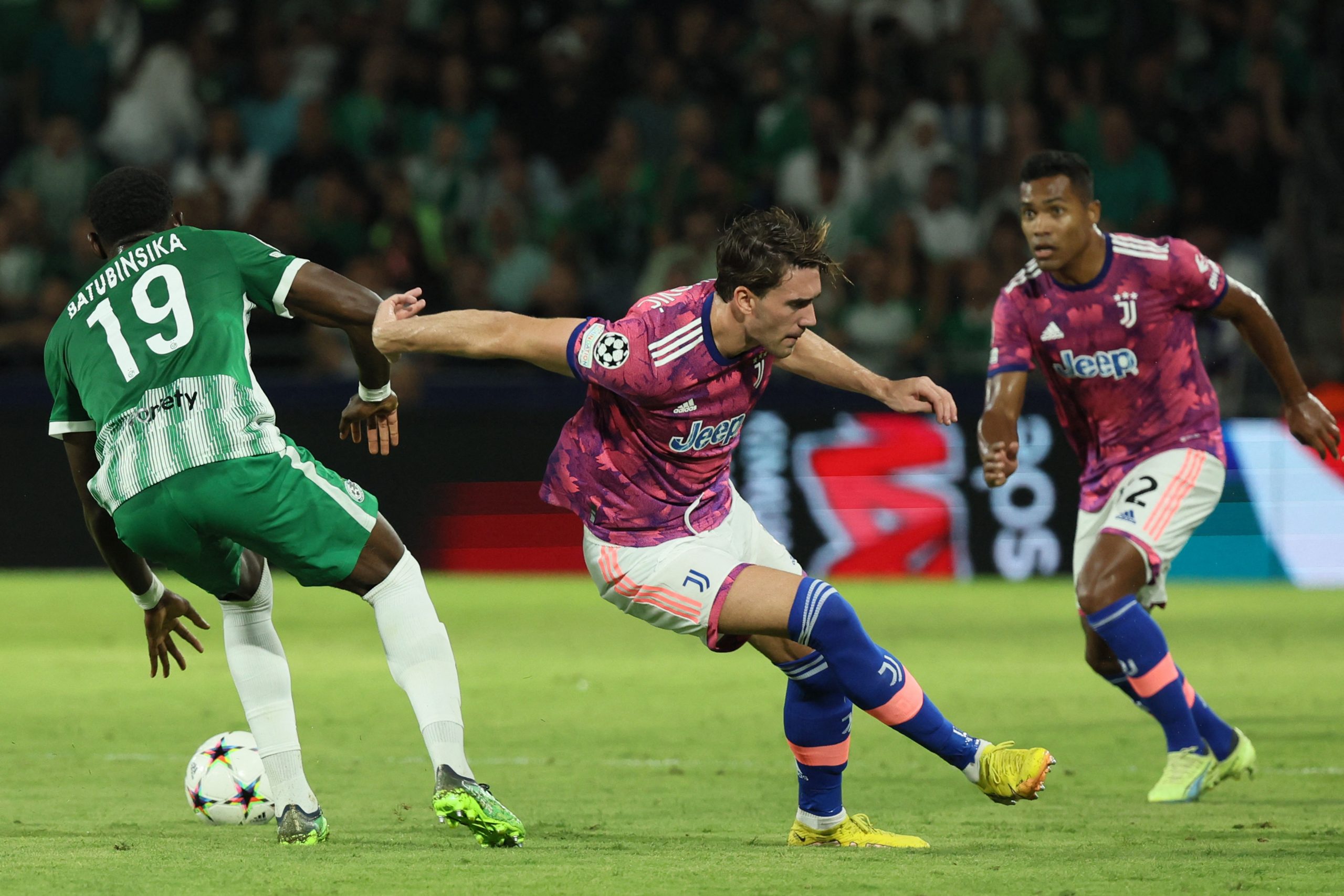 Maccabi Haifa's French defender Dylan Batubinsika (L) vies for the ball with Juventus' Serbian forward Dusan Vlahovic (C) during the UEFA Champions League group H football match between Israel's Maccabi Haifa and Italy's Juventus at the Sammy Ofer stadium in the city of Haifa on October 11, 2022. (Photo by JACK GUEZ / AFP) (Photo by JACK GUEZ/AFP via Getty Images)