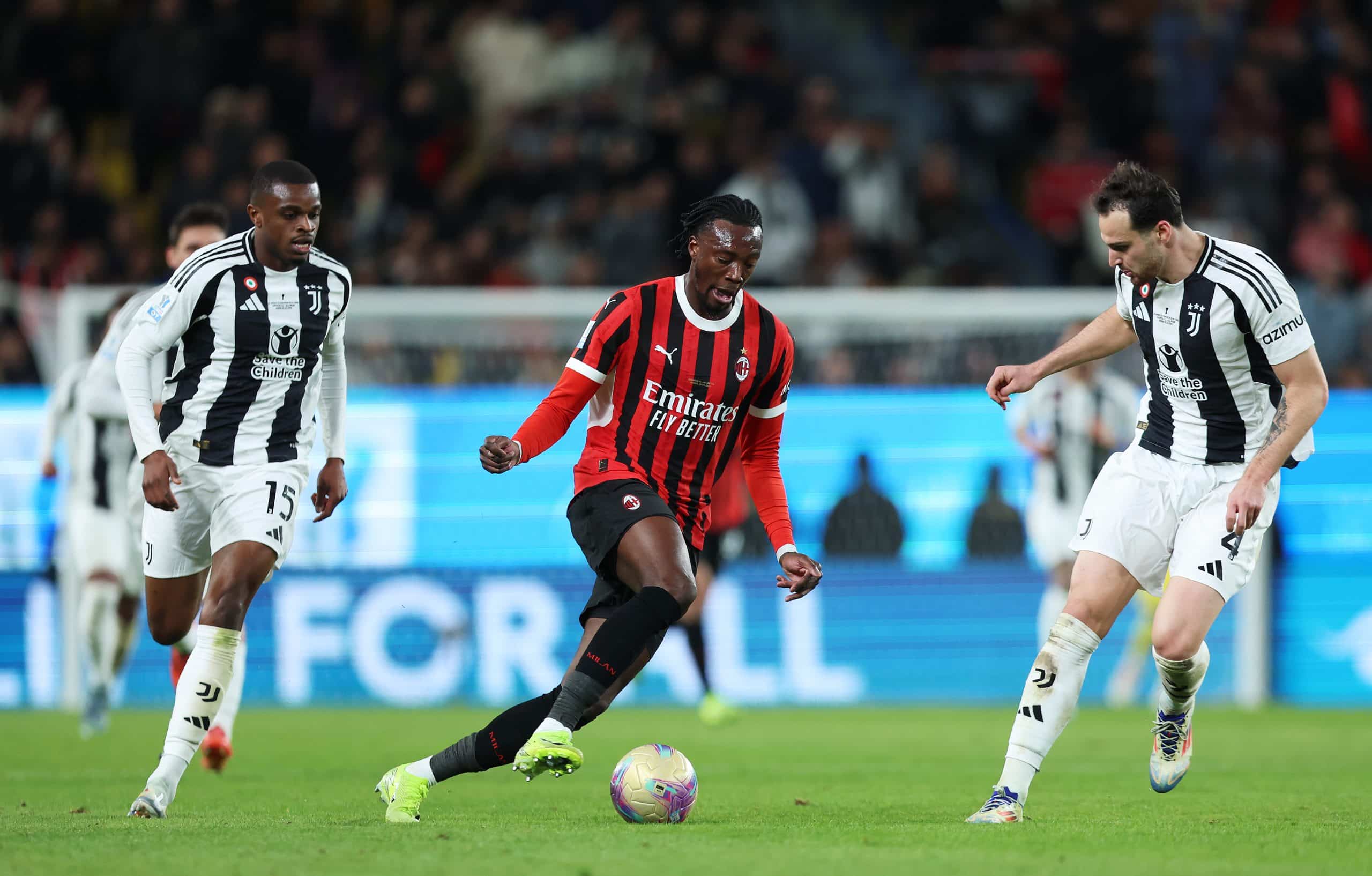 RIYADH, SAUDI ARABIA - JANUARY 03: Tammy Abraham of AC Milan runs with the ball whilst under pressure from Pierre Kalulu and Federico Gatti of Juventus during the Italian Super Cup Semi-Final match between AC Milan and Juventus at Al Awwal Park on January 03, 2025 in Riyadh, Saudi Arabia. (Photo by Yasser Bakhsh/Getty Images)